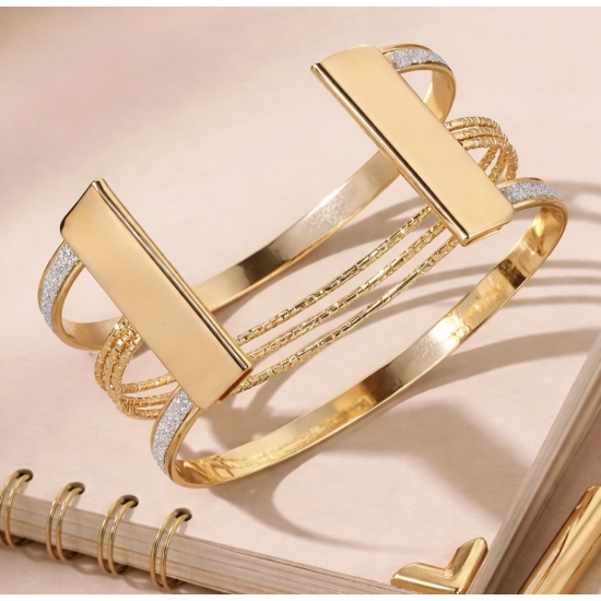 Bransoletka mankietowa w kolorze złotym.